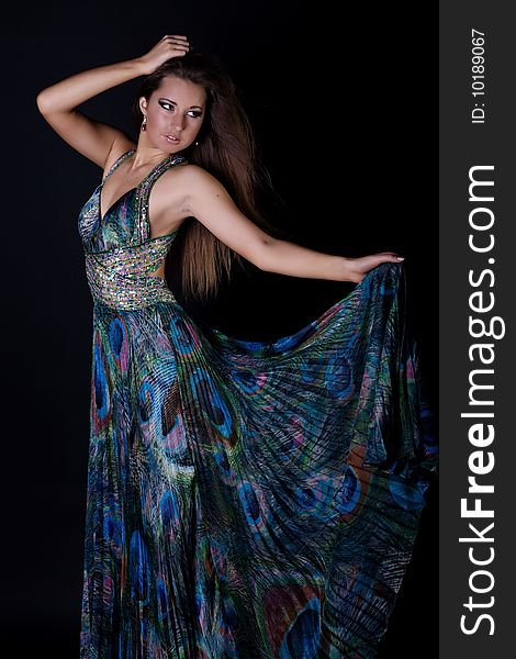 Young woman in beautiful long dress isolated on black