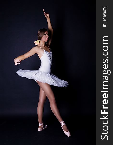 Ballerina in white tutu on black background