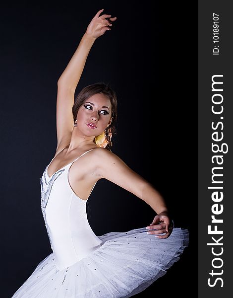 Ballerina in white tutu on black background