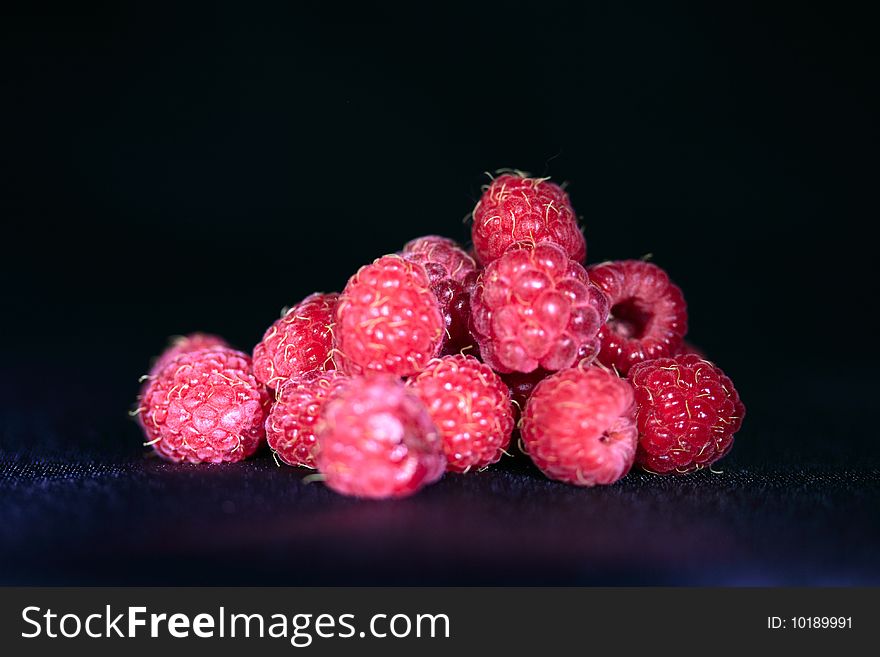 Ripe raspberries against a black background