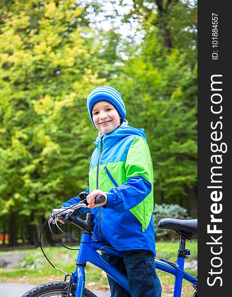 Kid boy outdoor in park with bike. Kid boy outdoor in park with bike.