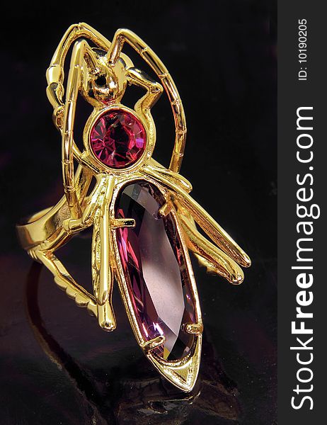 Ring in the form of a gold grasshopper with red crystals