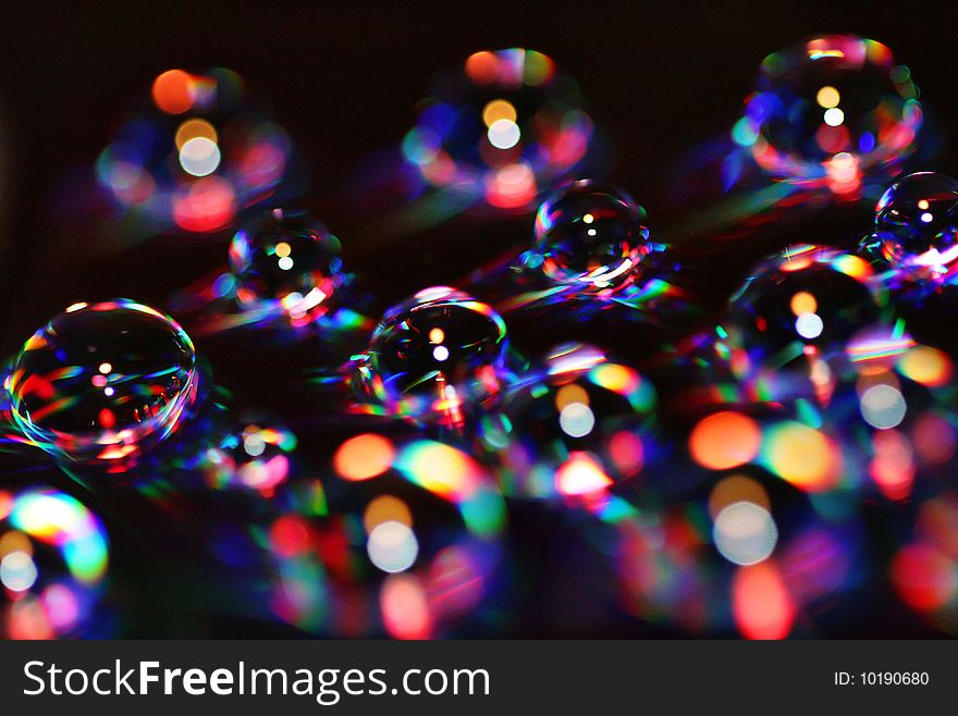 Water drops over a DVD become colorful bubbles