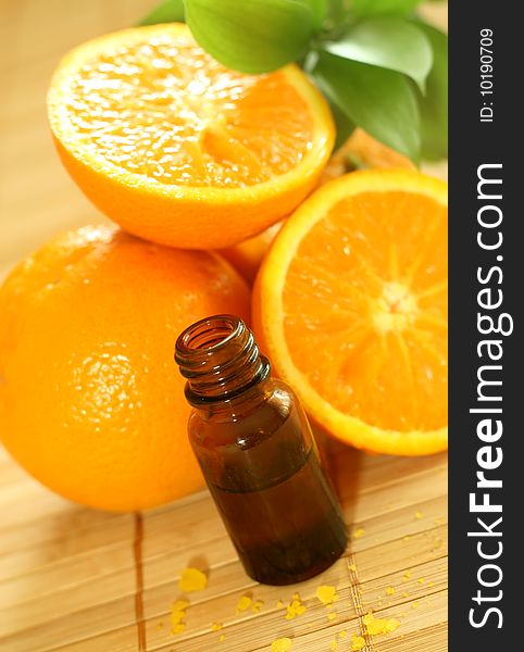 bottle of essence oil and fresh oranges