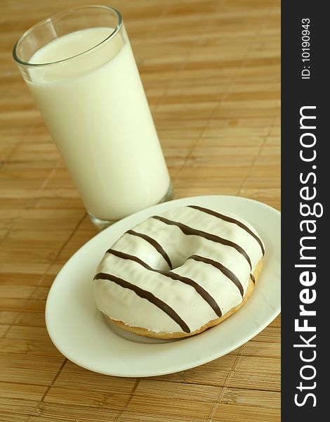 Breakfast. Glass of milk and donut on bamboo background. Breakfast. Glass of milk and donut on bamboo background.