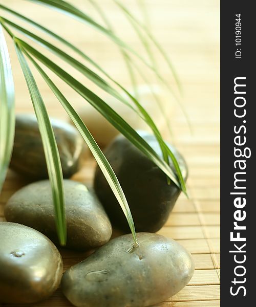 Stones and green leaves on bamboo background. Stones and green leaves on bamboo background.