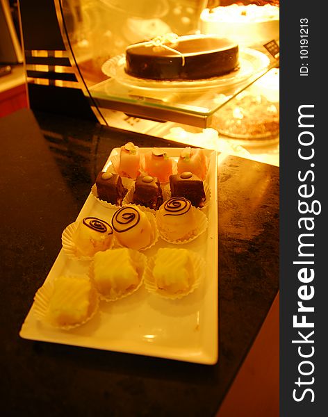 Fresh bakery items, with cakes in the background. Fresh bakery items, with cakes in the background