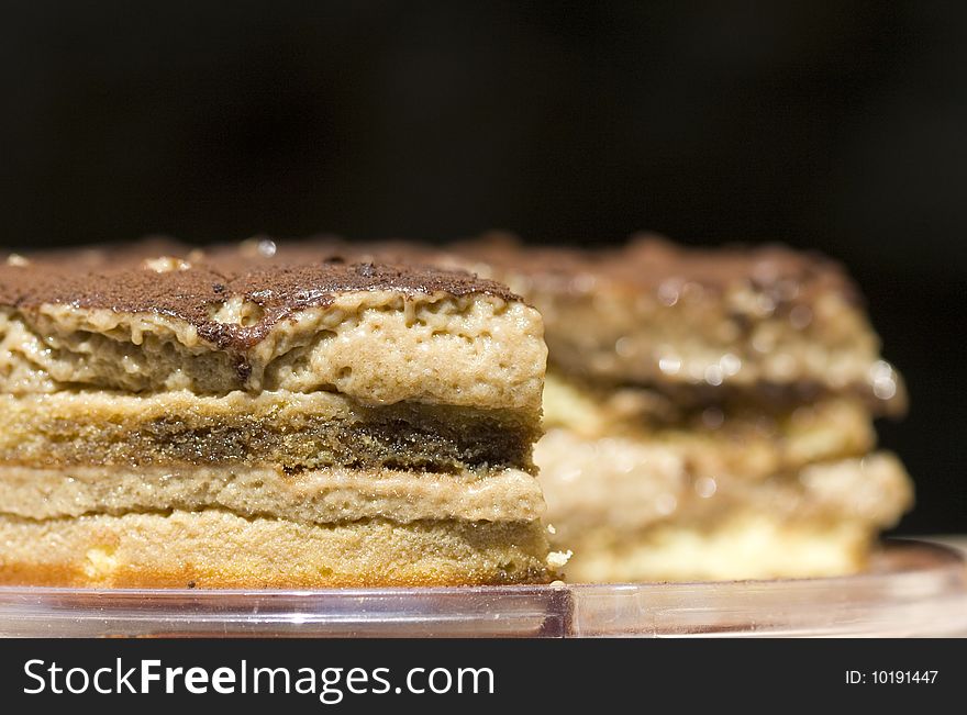 Italian layered Tiramisu Cake isolated on black. Italian layered Tiramisu Cake isolated on black