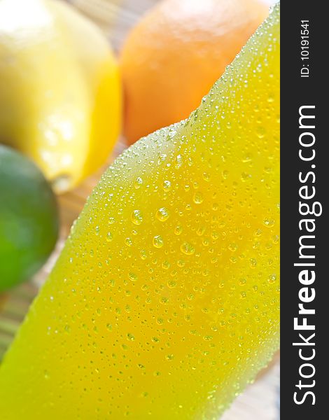 Close up shot of ice cold drink with some fruits on the background