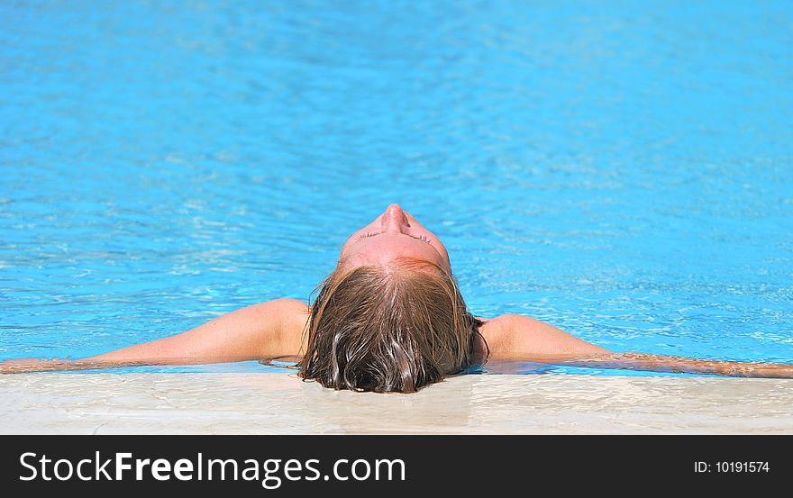 Woman relaxing in blue swimming waterpool. Woman relaxing in blue swimming waterpool