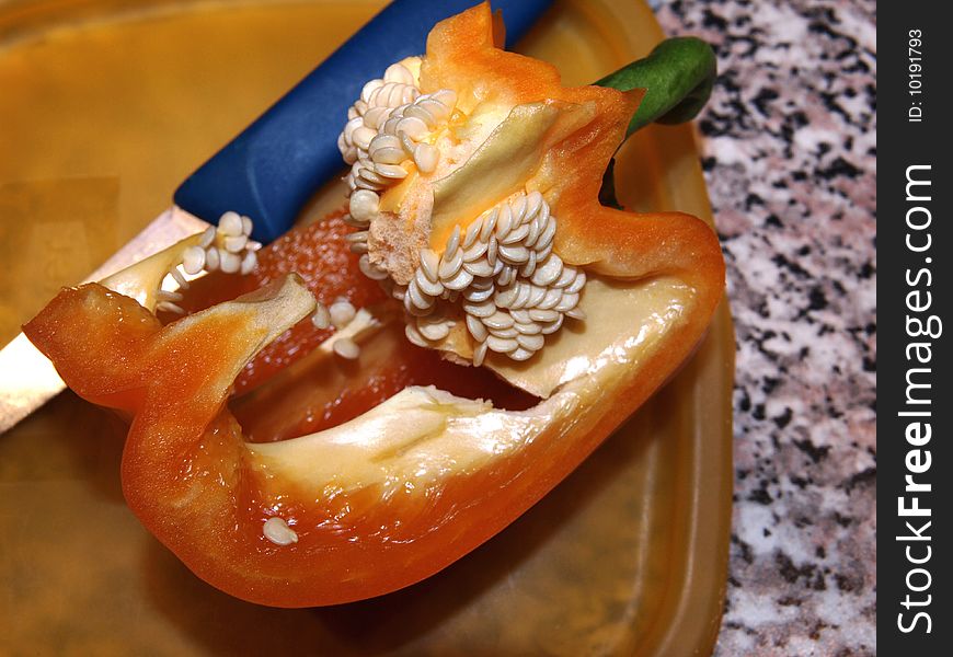 Orange tasty pepper with knife. Orange tasty pepper with knife