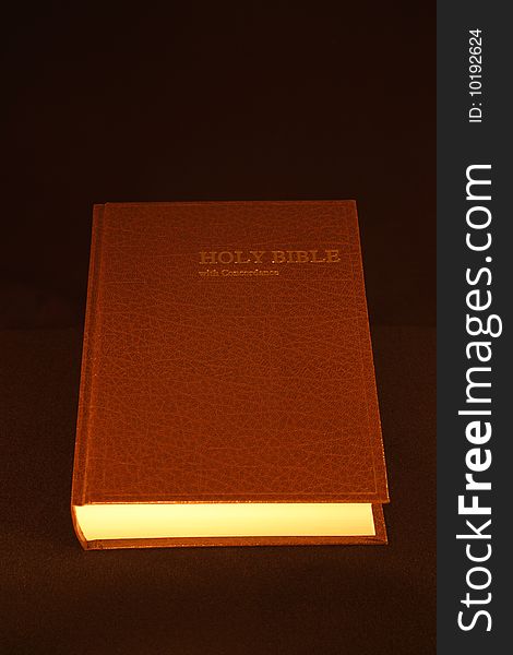 The Holy Bible under candle light.