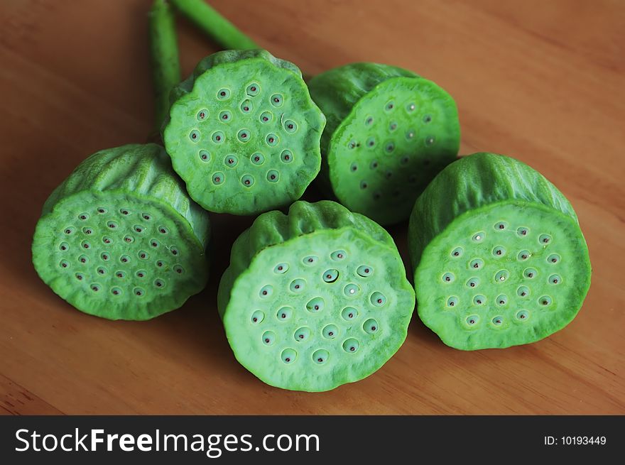 Ripe lotus seedpod on wood