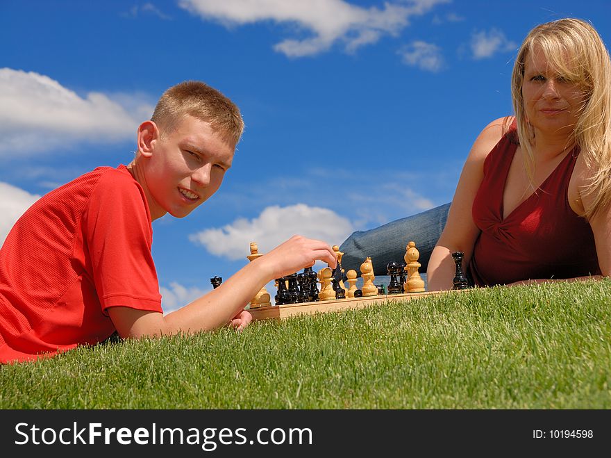 Son play chess with mother. Son play chess with mother.