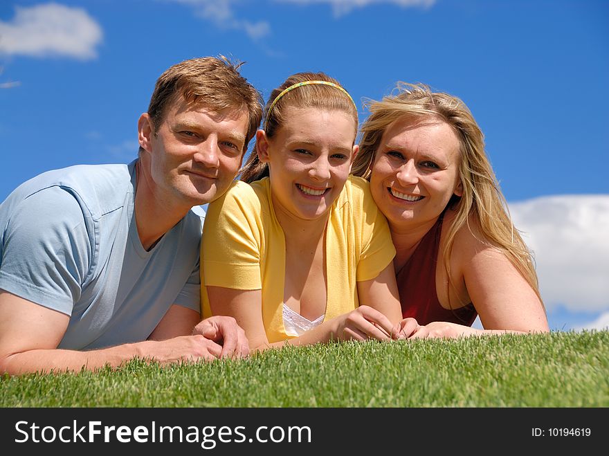 Daughter with parents on grass area. Daughter with parents on grass area