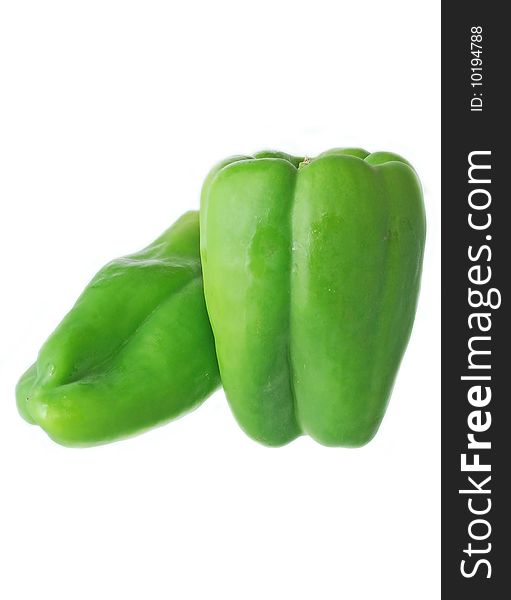 Two fresh green peppers over white