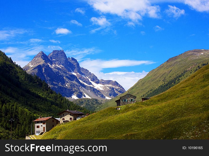 Mountain refuges with grass and blue sky