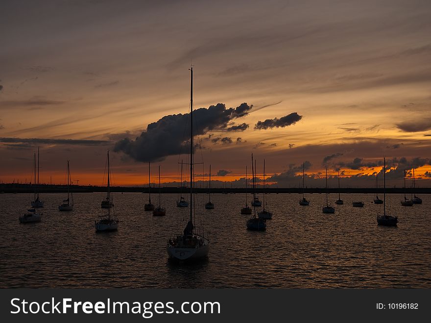 Port with docked yachts at golden sunset