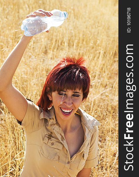 Woman shower with bottle of  water in  a field outdoors. Woman shower with bottle of  water in  a field outdoors