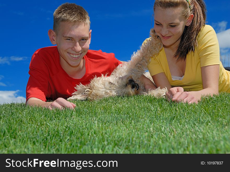 Siblings together wrestling with dog. Siblings together wrestling with dog