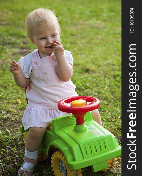 Little girl sitting on a green car