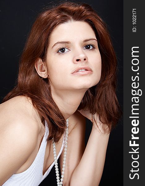 Sexy girl in white, with pearls , posing on black background. Sexy girl in white, with pearls , posing on black background