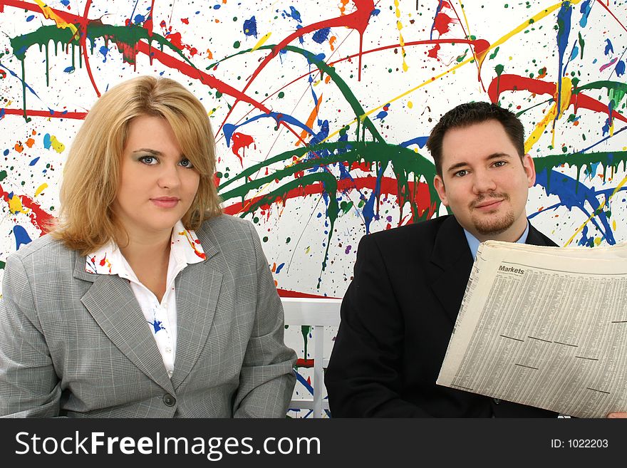 Professional woman and man with newspaper; paint splash background. Professional woman and man with newspaper; paint splash background