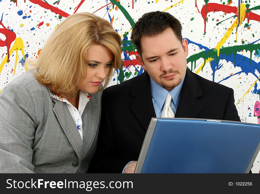Professional woman and man with laptop; paint splash background. Professional woman and man with laptop; paint splash background