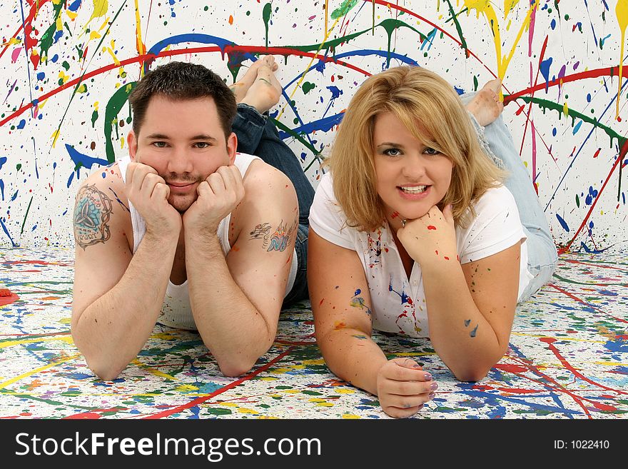 Young casual couple; splashed painted background. Young casual couple; splashed painted background