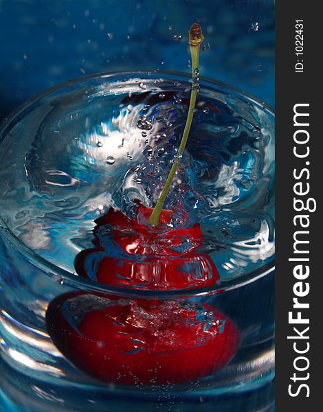 Cherry flopping down in to the glass of water. Cherry flopping down in to the glass of water