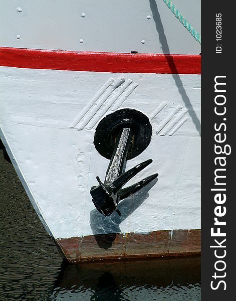 Black iron anchor on an old, white boat. Black iron anchor on an old, white boat.