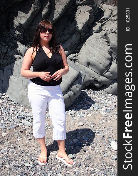 Young woman on Beach with glasses and pants on