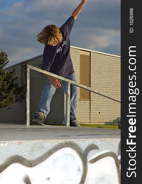 A young boy skateboarding up a ramp at a skate park. A young boy skateboarding up a ramp at a skate park