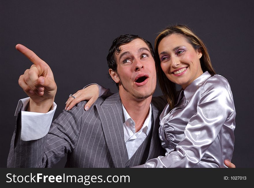 A man and woman embracing, laughing and pointing. A man and woman embracing, laughing and pointing