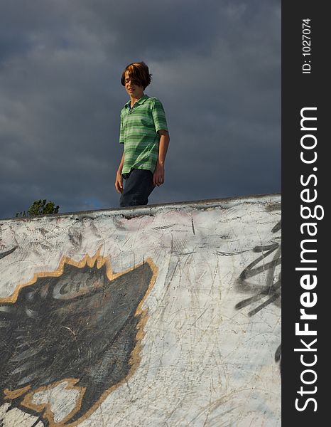 A young boy skateboarding down a ramp at a skate park. A young boy skateboarding down a ramp at a skate park