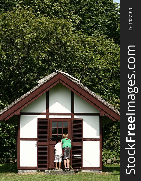 Castel of fredensborg in denmark a sunny sommer day, children looking through a window of the queen garden house. Castel of fredensborg in denmark a sunny sommer day, children looking through a window of the queen garden house