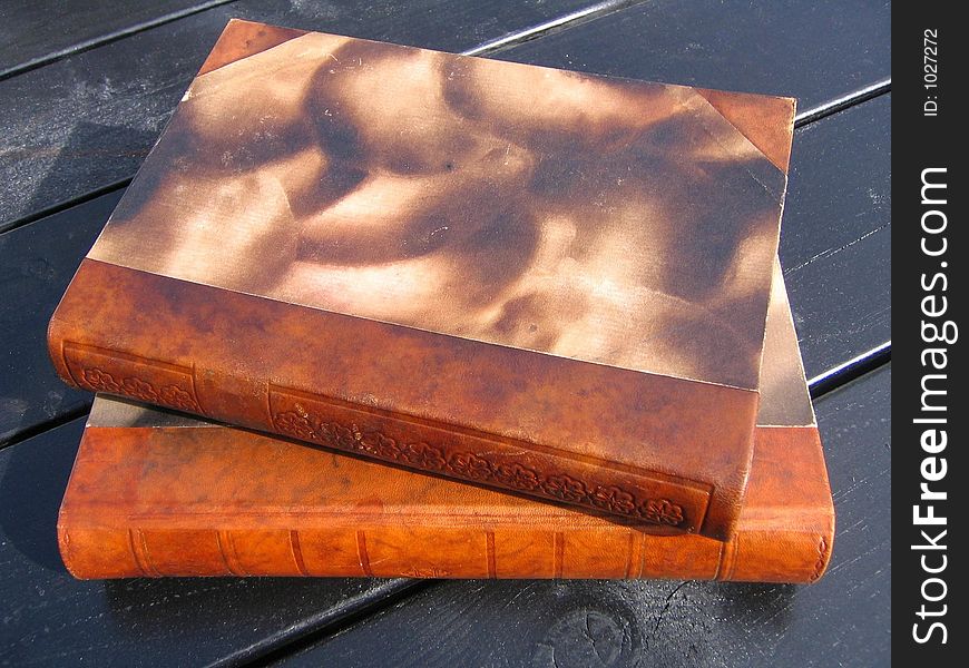 Two antique books on a rustic table