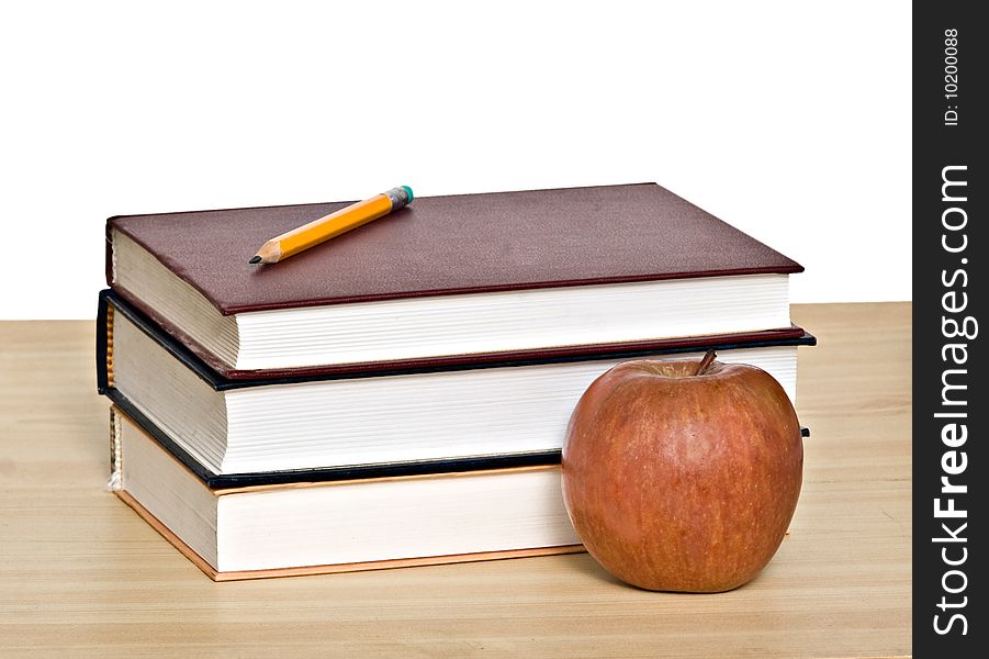 Red apple and pencil on top of books. Red apple and pencil on top of books