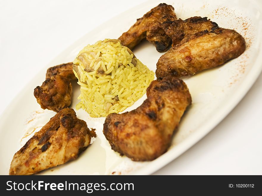 Five chicken wings arranged on a white plate with rice garnish in middle of plate isolated on white background,see more in <a href=http://www.dreamstime.com/restaurant-food-rcollection10721-resi828293>Restaurant food</a>