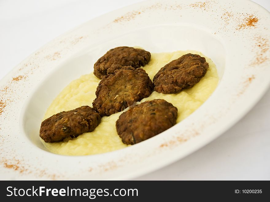 Meat ball with mashed potatoes garnish on a white plate decorated with red chili,see more in Restaurant food