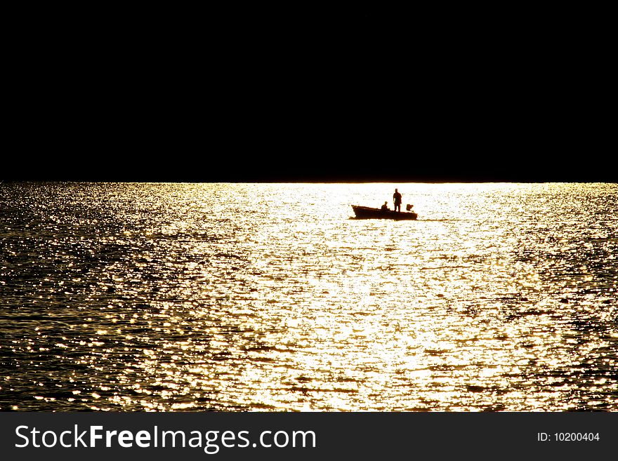 A boat sail at backlight of sunset. A boat sail at backlight of sunset