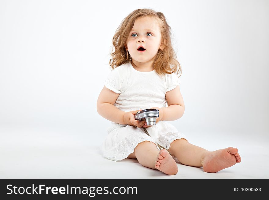 Little girl with camera on gray background