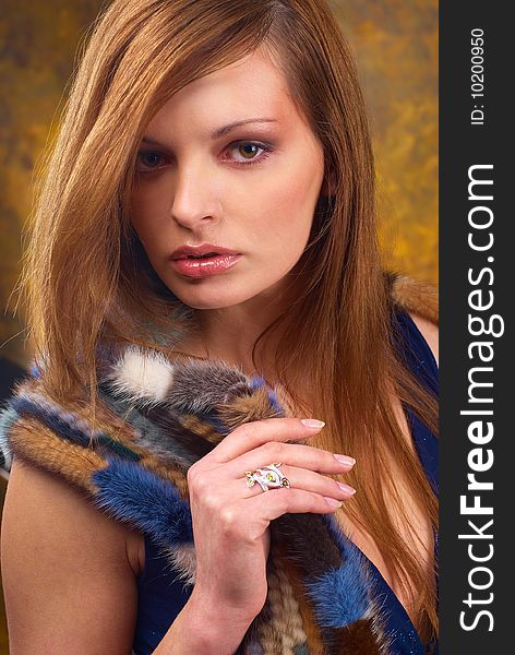 Portrait of a young beautiful brunettes, with a ring on the finger and in the fur cape blue. Portrait of a young beautiful brunettes, with a ring on the finger and in the fur cape blue