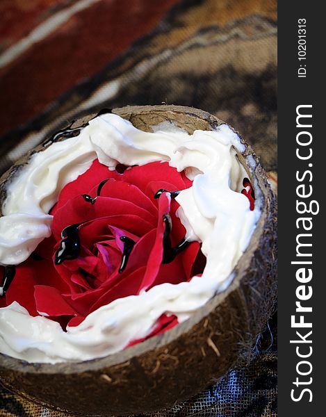 Close up with coconut, red rose and chocolate on white plate. Close up with coconut, red rose and chocolate on white plate