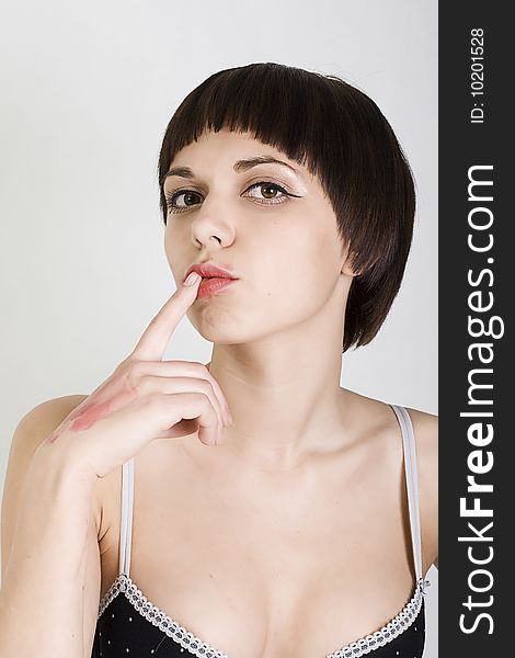 Pretty girl holding a finger in the mouth, showing that you have to be quiet