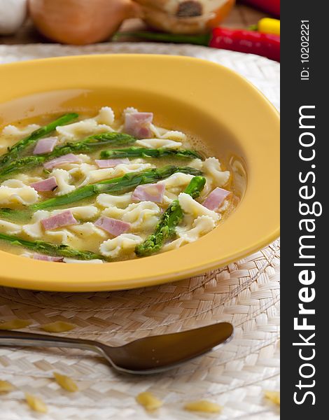 Vegetable bouillon soup with asparagus and ham