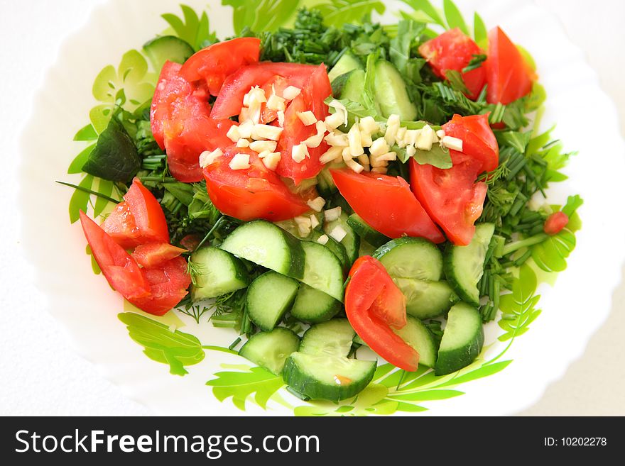 Garden healthy salad with tomato cucumbers and garlic