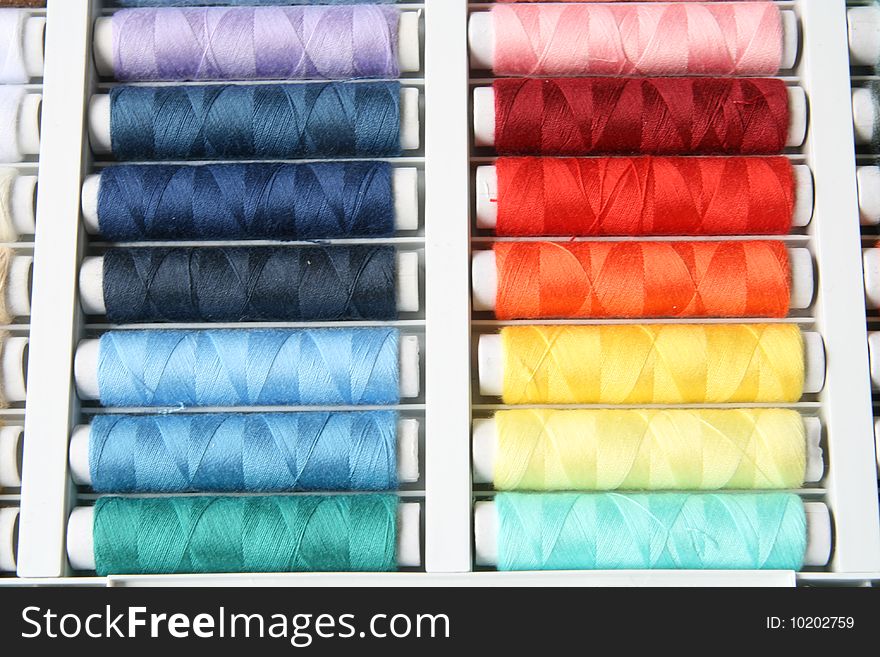 Colorful bobbins of sewing thread in a box. Colorful bobbins of sewing thread in a box