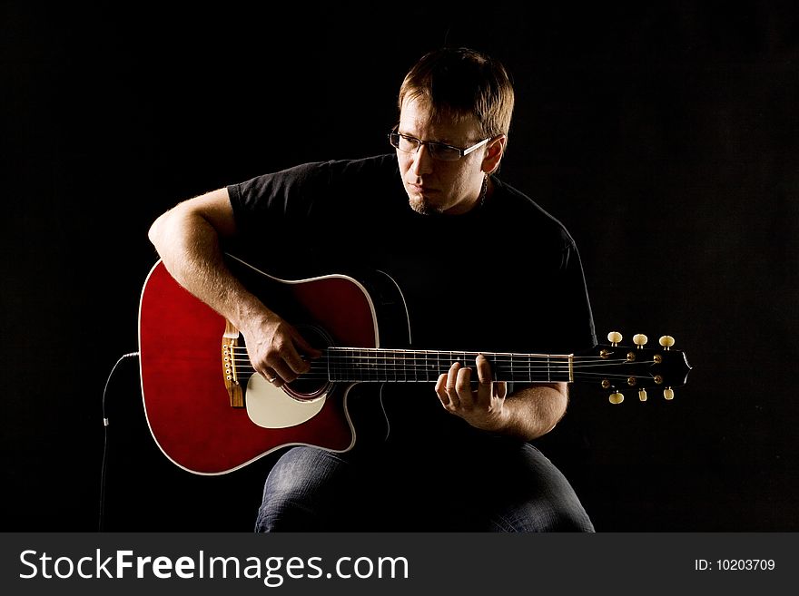 Photo of a young man playing the guitar. Photo of a young man playing the guitar