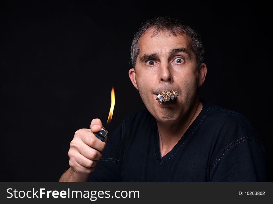 A man with many cigarettes on black background. A man with many cigarettes on black background